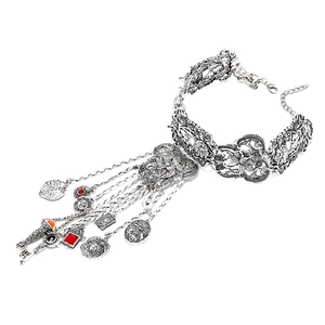 Détail d'un choker bohème vintage argenté avec plaques florales et pendentifs variés