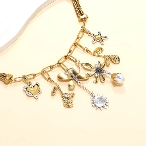 Vue macro d'un collier bohème avec pendentifs or et argent et une perle fantaisie