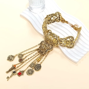 Détails d'un collier vintage avec pendentifs pièces et clés sur une assiette blanche