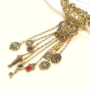 Détail du collier vintage en alliage doré avec pièces Medusa et pendentifs clés antiques