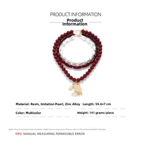 Detailed spec sheet of a triple-layered necklace with a gold crab pendant and pearls