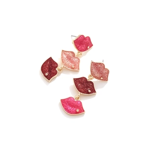 Detailed macro view of triple tiered glitter lip earrings with red and pink enamel