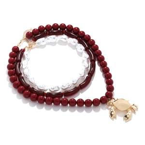 Multi-layer necklace with irregular pearls and crab pendant in gold and burgundy
