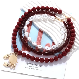 Multi-layer beaded necklace featuring a gold crab pendant and baroque style pearls