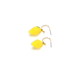 Close-up of yellow lemon fruit earrings with textured resin and gold metal hooks