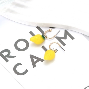 Vibrant 3D lemon pendant earrings with realistic texture and gold hooks on a white background