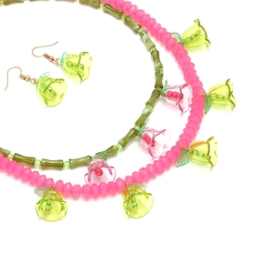 Detail of handmade beaded necklace with colorful trumpet flower pendants and earrings