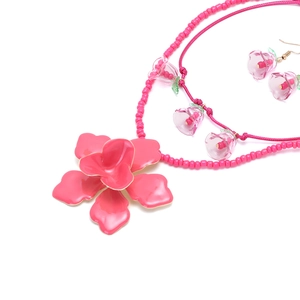 Dettaglio del set di collana e orecchini di perline con ciondoli a fiore rosa smaltato