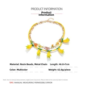 Détails du collier de perles superposées avec breloques banane et accents floraux