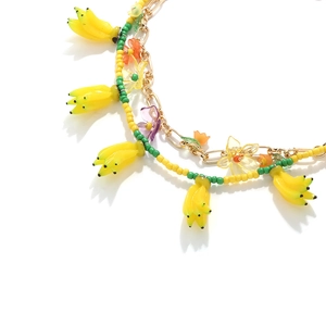 Détail du collier de perles d'été avec breloques bananes et pendentifs fleurs