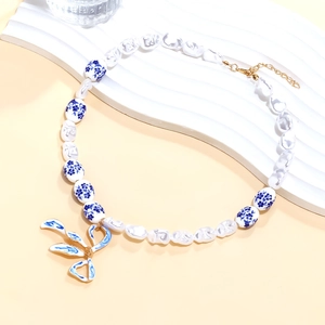 Baroque pearl necklace with blue bow pendant and porcelain beads in chinoiserie style