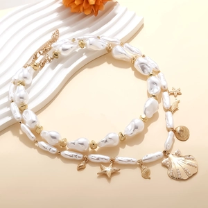 Dettaglio della collana di perle barocche con ciondoli a forma di stella marina e conchiglia