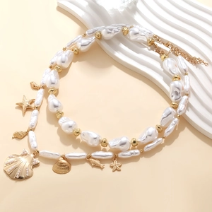 Collana di perle barocche con ciondoli a forma di conchiglia e stella marina dorata