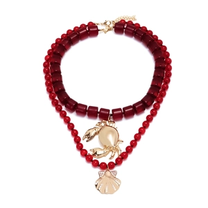 Collier à double rangée de perles avec pendentif crabe doré et breloque en coquillage