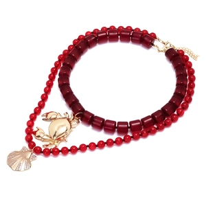 Collier double rang de perles rouges avec pendentifs crabe et coquillage dorés
