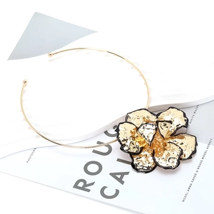 Collier torque doré avec un grand pendentif fleur à plusieurs couches et contours noirs