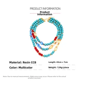 Detail showing multi-layer resin beads in turquoise and red colors with gold clasp