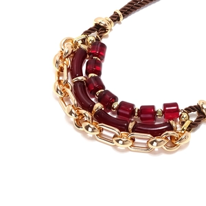 Détail du collier multicouche en métal avec résine bordeaux et cordelette tressée