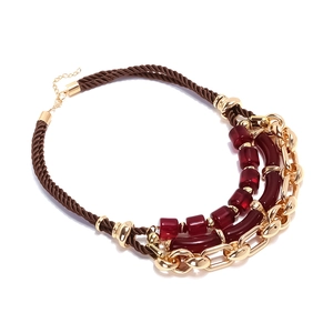 Détail d'un collier multicouche en résine et chaîne dorée avec fermoir mousqueton