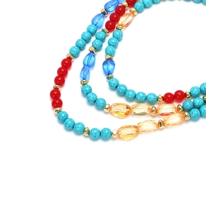 Macro shot of colorful bohemian layered beads with turquoise and golden accents