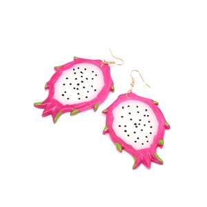 Détail de boucles d'oreilles pitaya avec peau rose et pulpe blanche et noire