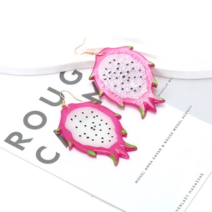 Boucles d'oreilles créatives en forme de fruit du dragon rose sur plateforme blanche