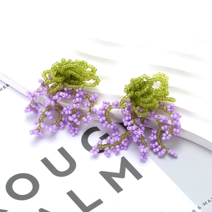Bohemian beaded tassel earrings featuring green flower bud and purple cluster fringe