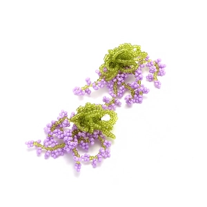 Detailed shot of handmade beaded tassel earrings with purple flowers and green leaves
