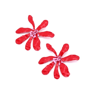 Détail de boucles d'oreilles fleurs rouges mates avec texture martelée et perles roses