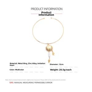 Detail of golden shell choker necklace featuring baroque pearl and small fish charms
