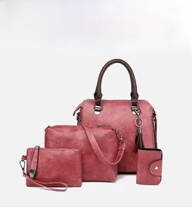 Dettaglio di un set da quattro pezzi rosso chiaro con borsa shopper, tracolla, pochette e portacarte