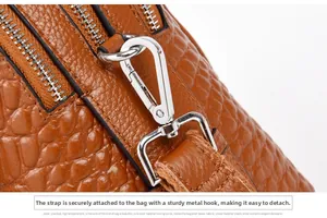 Close-up of brown crocodile embossed leather with silver metal hooks for straps