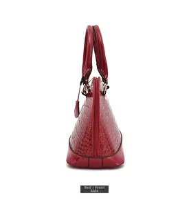Dettaglio della borsa a mano rossa in pelle di coccodrillo goffrata con zip in metallo