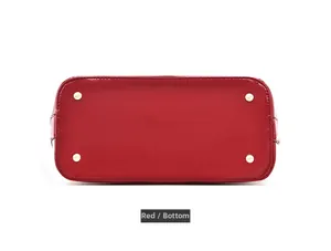Dettaglio del fondo della borsa in pelle verniciata rossa con borchie dorate