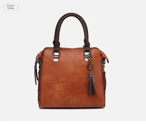 Dettaglio frontale della borsa vintage marrone con nappa a frange e dettagli argentati