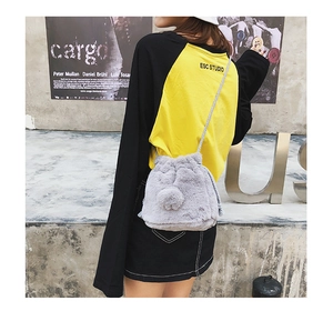 Close-up of grey plush bucket bag featuring soft faux fur texture and thick rope strap