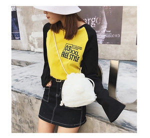 Detail view of the white plush drawstring bucket bag with soft faux fur texture