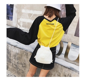 Close-up of the white fluffy plush texture and drawstring cord on the bucket bag