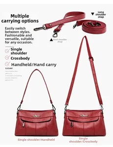 Detail of red pebbled leather handbag with adjustable straps and silver logo