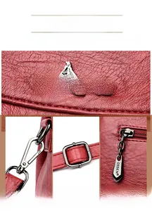 Detailed close-up of red lychee leather texture, kangaroo metal logo and silver zipper pull