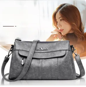 Detailed view of dark grey crossbody bag with lychee pattern and kangaroo logo
