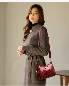 Détail du sac bandoulière bordeaux en cuir verni façon crocodile avec logo kangourou doré