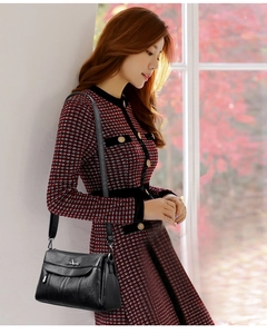 Detail of black faux leather crossbody bag featuring a front zipper and magnetic flap closure