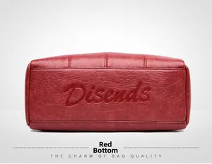 Macro shot of red pebble leather shoulder bag base with Disends brand logo embossing