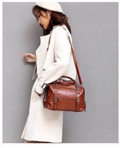 Brown vintage oil wax leather Boston handbag with adjustable strap shown on model