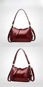 Détail d'un sac à main rouge en cuir verni avec motif crocodile et zip doré