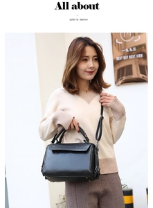Chic black crocodile embossed Boston bag shown on a street style model for daily wear
