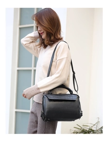 Detail of black crocodile pattern flap and adjustable strap on the Boston bag