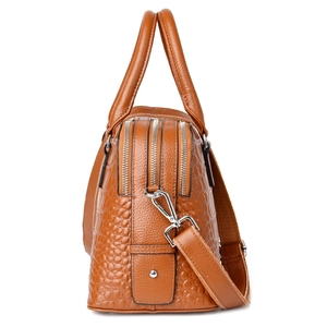 Brown crocodile pattern crossbody bag with twin zippers and silver hardware in side view