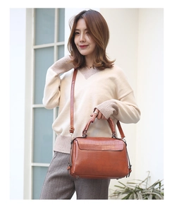 Close-up of caramel brown Boston bag with crocodile texture and adjustable strap